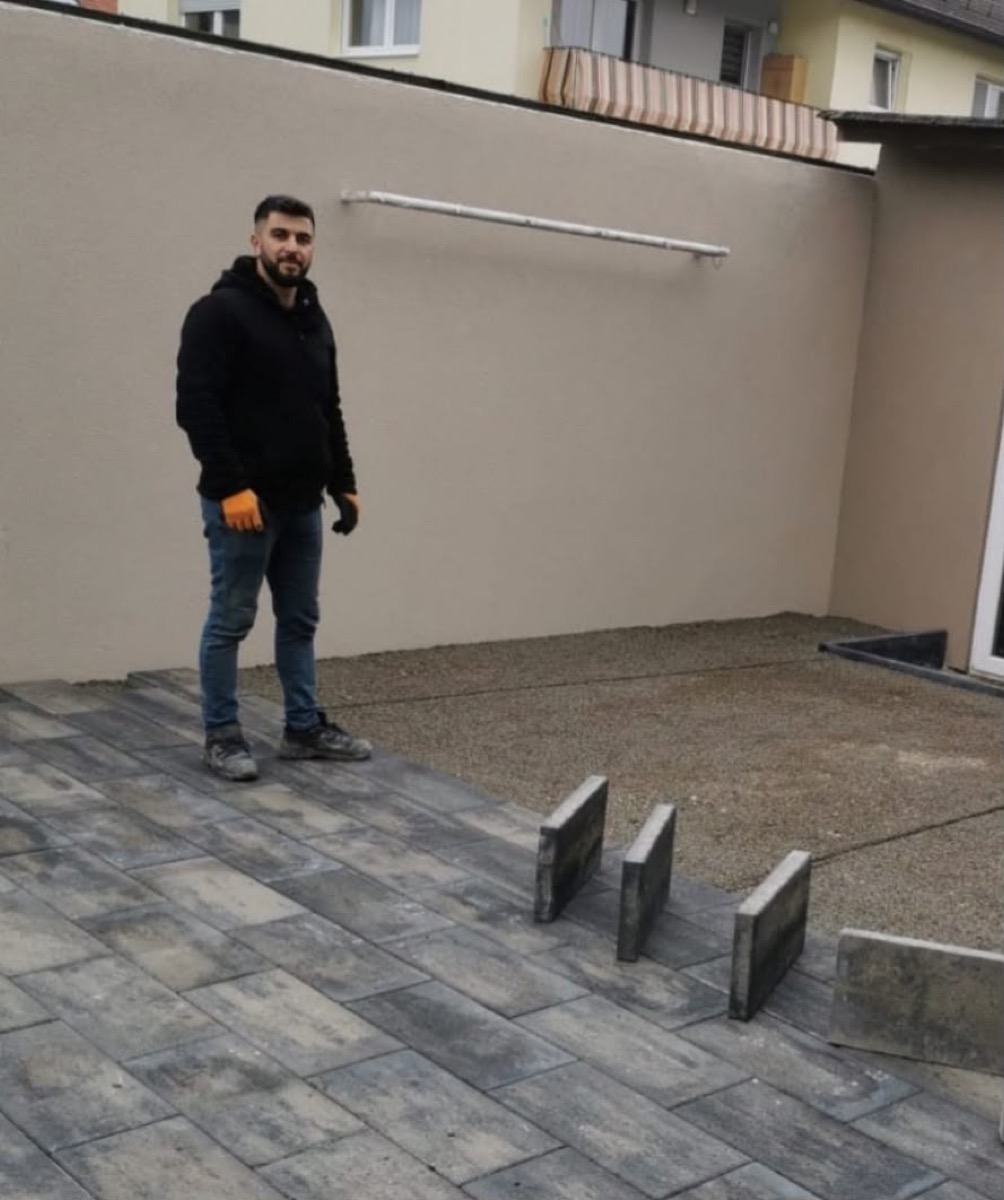 Terrassenbau: verlegte Terrassenplatten mit Randsteinen und vorbereitetem Kiesbett